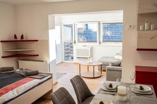 Habitación con cama y sala de estar con mesa. en Apartmaji Ježek Kope, en Šmartno pri Slovenj Gradcu