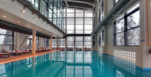 a swimming pool in a building with windows at Euphoria Club Hotel in Borovets