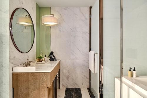 a bathroom with a sink and a mirror at Rosewood Bangkok in Bangkok