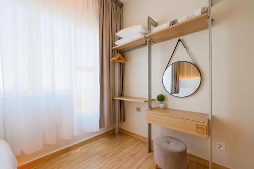 ein Schlafzimmer mit einem Spiegel, einem Schreibtisch und einem Fenster in der Unterkunft MujiZen Retreat Seaview Apartment Amber Cove in Malakka