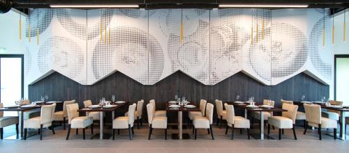 a dining room with tables and chairs and a large chandelier at Euphoria Club Hotel in Borovets
