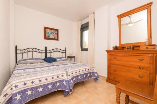 a bedroom with a bed and a dresser and a mirror at Paraiso Costero - Adults Only - in Conil de la Frontera