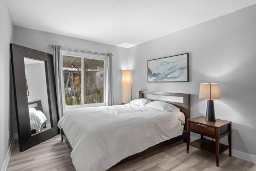 1 dormitorio con cama blanca y ventana en Traveler's Dream SD Pool Home Game Room, en San Diego