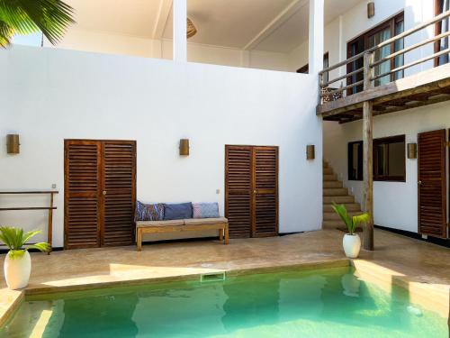 uma villa com uma piscina e uma casa em Kholle Villa em Jambiani