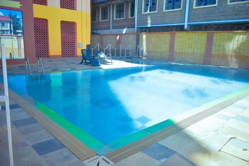 a large swimming pool with blue water in a building at Balozi Luxury Homes in Nanyuki