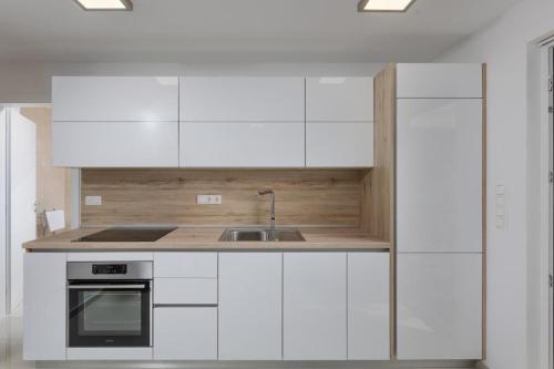 a kitchen with white cabinets and a sink at Premium Apartments in Vantačići