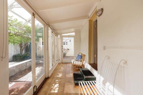 an empty hallway with two chairs and large windows at Wollaston House by the BnB Collection in Albany