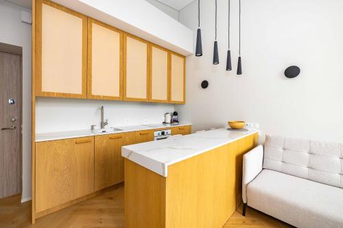 eine Küche mit Holzschränken und einem Waschbecken und einem Stuhl in der Unterkunft Vanagupes Park Apartments, By Cohost in Palanga