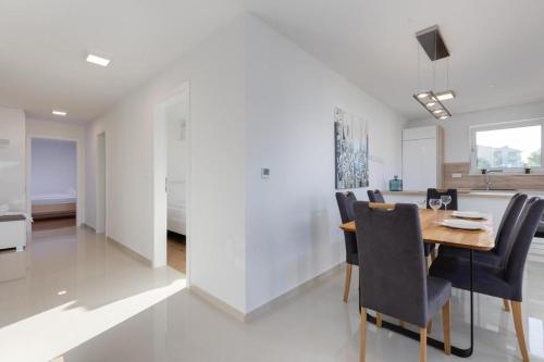 a dining room and kitchen with a table and chairs at Premium Apartments in Vantačići