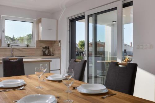 a dining room with a table and chairs and a kitchen at Premium Apartments in Vantačići