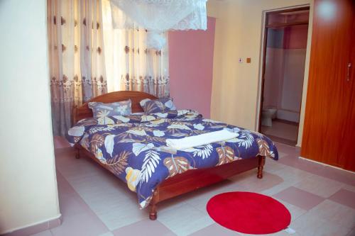 a bedroom with a bed with a blue comforter at Balozi Luxury Homes in Nanyuki