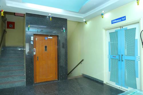 einen Aufzug mit Holztür und Treppe in einem Gebäude in der Unterkunft Hotel Anjani in Lātūr