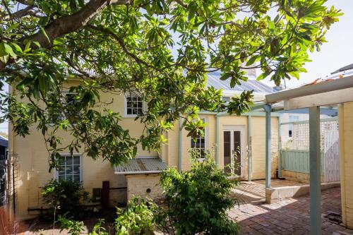 an old yellow house with a tree in front of it at Wollaston House by the BnB Collection in Albany