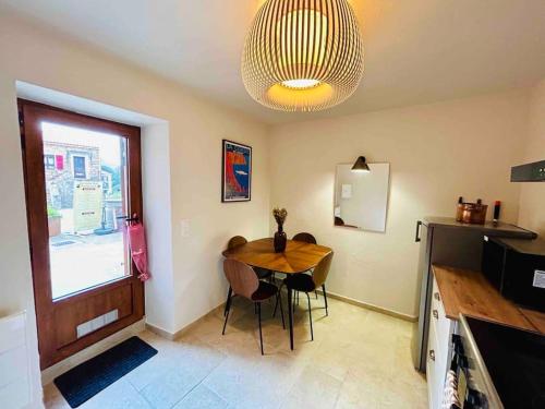 Un comedor con una mesa y una lámpara de araña. en Charmant petit appartement place de l eglise, en Piana