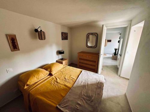une chambre avec un lit, une commode et un miroir dans l'établissement Charmant petit appartement place de l eglise, à Piana