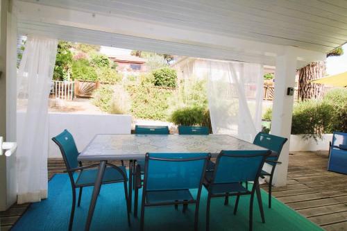 une table et des chaises assises sur une terrasse dans l'établissement GASMIM29 - Golfe de St-Tropez, chalet climatisé dans domaine arboré, à Gassin