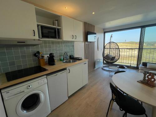 - une cuisine avec un évier et une table à manger dans l'établissement Appartement de charme, vue océan, à Lacanau