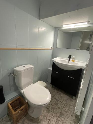 une salle de bain avec des toilettes blanches et un lavabo dans l'établissement Appartement de charme, vue océan, à Lacanau