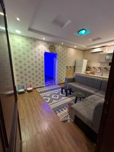 uma sala de estar com um sofá e uma porta azul em استراحة رفييف em Khalij Salman