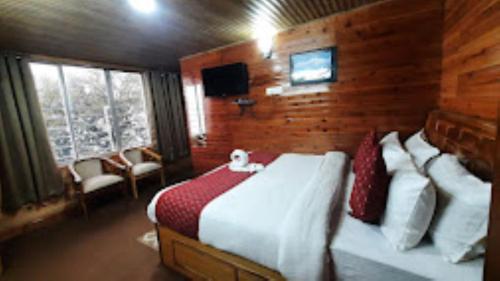 1 dormitorio con 1 cama grande en una habitación de madera en View Point Residency , Darjeeling en Darjeeling