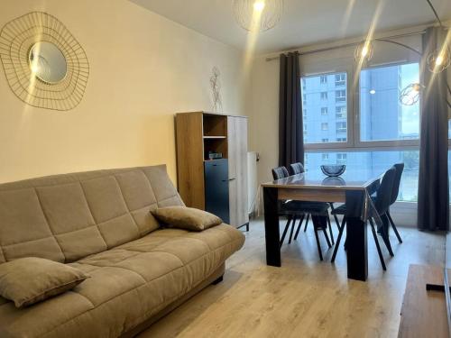 - un salon avec un canapé et une table à manger dans l'établissement VULCAIN 2, 11ème, Ile de Nantes, 4pers, parking inclus, à Nantes