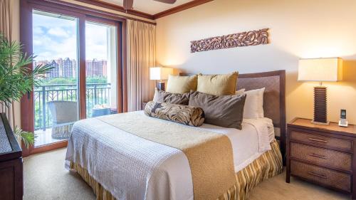 1 dormitorio con 1 cama y vistas a un balcón en Ko Olina Beach Villas B608 en Kapolei