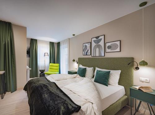 una camera con un grande letto con testiera verde di Boutique Hotel Am Park a Valdaora