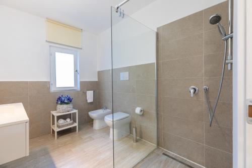 un bagno con wc e doccia in vetro di Stazzo San Teodoro Piscina Condivisa a San Teodoro