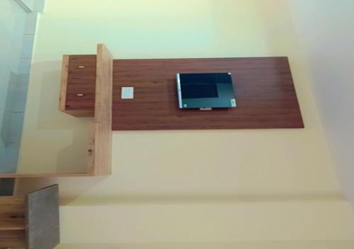 einen Laptop auf einem Holzregal an einer Wand in der Unterkunft Urban Lounge in Rājahmundry