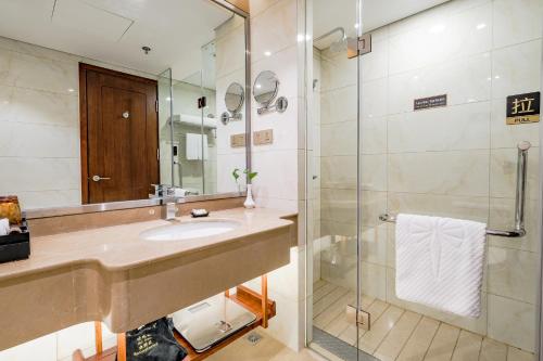 een badkamer met een wastafel en een douche bij 潍坊富华大酒店b座 in Weifang