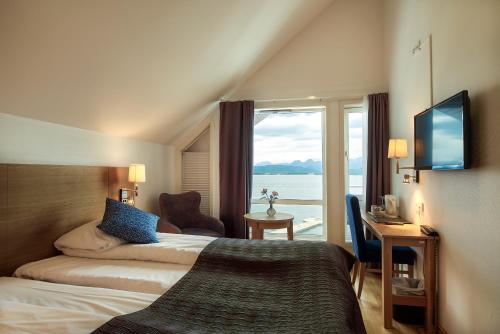 um quarto de hotel com uma cama e uma grande janela em Molde Fjordhotell - by Classic Norway Hotels em Molde