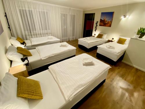 a hotel room with three beds and a room with at Yose Apartment in Poznań