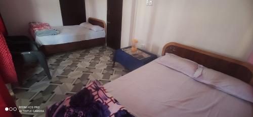 Cette petite chambre dispose d'un lit, d'une table et d'une sidx. dans l'établissement Saumya Home Stay, à Munsyari