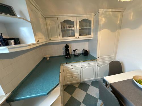 une cuisine avec des placards blancs et un comptoir vert dans l'établissement Willkommen in Crossen, 