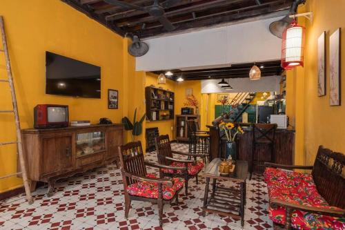 uma sala de estar com cadeiras e uma televisão na parede em Ben Thanh Vietnamese cultural house by SSens Homes em Ho Chi Minh