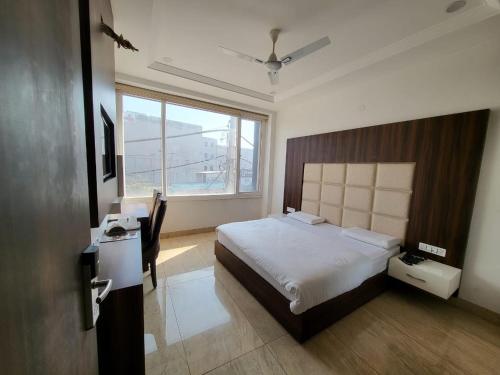 a bedroom with a large bed and a window at HOTEL AROMA in Kurukshetra