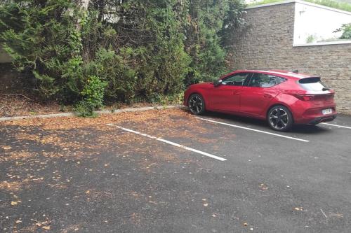 un'auto rossa parcheggiata in un parcheggio di La Fontaine,T2 au calme , parking, vue Erdre a Nantes
