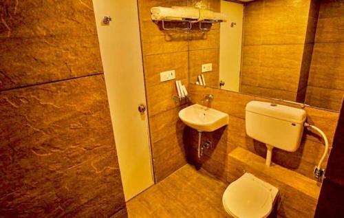 bagno con lavandino, servizi igienici e specchio di The Weekend Address Managed By Stay Cation a Surat
