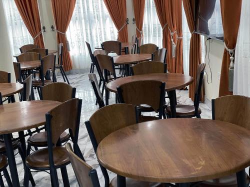 Cette chambre est dotée de tables et de chaises en bois. dans l'établissement YE BISA FIE HOTEL, 