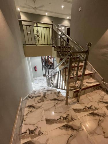 un escalier avec une balustrade en métal et un sol en marbre dans l'établissement YE BISA FIE HOTEL, 