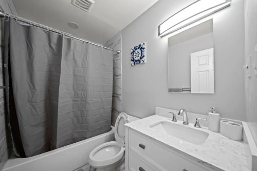W łazience znajduje się umywalka, toaleta i lustro. w obiekcie Spacious 4 Bed Room Haven in Clawson Near Bham w mieście Clawson