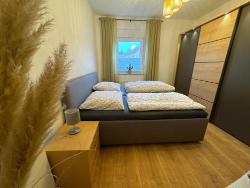 two beds in a room with a couch and a window at Willkommen in Crossen 