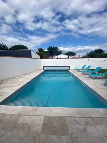 - une piscine avec 2 chaises longues dans l'établissement Pretty house with heated pool, close to the ocean, au Bois-Plage-en-Ré