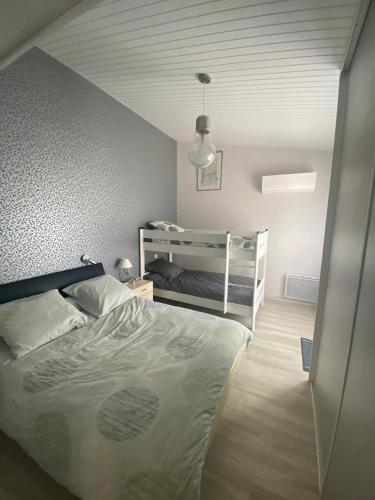 une chambre avec un lit et un lit superposé dans l'établissement Pretty house with heated pool, close to the ocean, au Bois-Plage-en-Ré