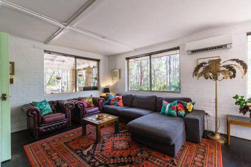 a living room with a couch and chairs and a table at Bushy Sleeps - Eco Friendly Tranquil Escape in Gnarabup