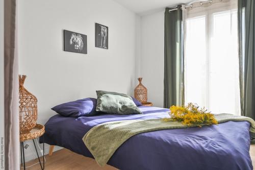 - une chambre avec un lit doté de draps violets et une fenêtre dans l'établissement T3, Balcons, cœur de Marseille, à Marseille