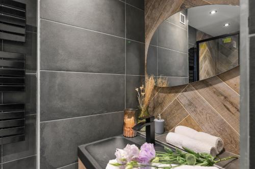 une salle de bain avec un lavabo et un miroir dans l'établissement T3, Balcons, cœur de Marseille, à Marseille