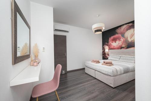 een slaapkamer met een bed en een roze stoel bij VILLA LATINI - Ideal for a family vacation. Heated pool. Local breakfast optional available in Svetvinčenat