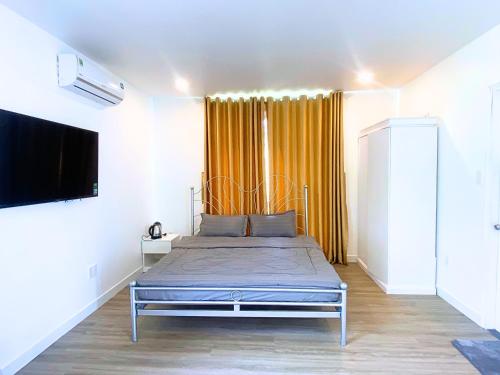 a bedroom with a bed and a television in it at Du Lịch Lâm Hà - Hồ Gia Trang Villas in Lam Ha