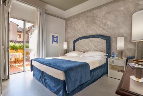 a bedroom with a bed with a blue blanket on it at Rivoli Boutique Hotel in Florence